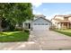 Charming blue two-story home with a two-car garage, front lawn, and mature trees, creating an inviting curb appeal at 19135 E Hickock Dr, Parker, CO 80134