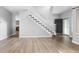 Open foyer with hardwood floors, staircase, modern door, and glimpse of the living room fireplace at 19135 E Hickock Dr, Parker, CO 80134