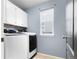 The laundry room includes modern washer and dryer, a window, and white cabinets at 19135 E Hickock Dr, Parker, CO 80134