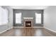 Stylish living room featuring a stone fireplace, hardwood floors, neutral walls, and large windows at 19135 E Hickock Dr, Parker, CO 80134