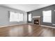 Cozy living room featuring a stone fireplace, hardwood floors, neutral walls, and natural light from the windows at 19135 E Hickock Dr, Parker, CO 80134