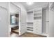 Walk-in closet featuring custom shelving and rods and an open door that leads to the bathroom at 19135 E Hickock Dr, Parker, CO 80134