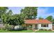 Charming home featuring a red tile roof, blue door, white brick, and a lush green lawn at 225 N Ivanhoe St, Denver, CO 80220