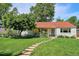 Inviting front yard with lush lawn, mature landscaping, and a charming blue front door at 225 N Ivanhoe St, Denver, CO 80220