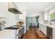 Well-lit kitchen with stainless steel appliances and hardwood floors leading to dining room at 225 N Ivanhoe St, Denver, CO 80220