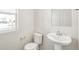 Clean and bright bathroom featuring a pedestal sink and a large window at 9303 Biscay St, Commerce City, CO 80022