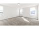 Sun-filled bedroom boasts plush neutral carpet, white walls, and multiple windows for ample natural light at 9303 Biscay St, Commerce City, CO 80022