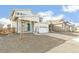 Beautiful home featuring a covered porch, gravel landscaping, and a two-car garage at 9303 Biscay St, Commerce City, CO 80022
