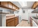 The cozy kitchen features a breakfast bar, white appliances, wood cabinetry and a skylight at 1792 S Pitkin Cir # B, Aurora, CO 80017