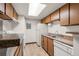 Efficient kitchen featuring ample wood cabinets, white appliances, and a skylight at 1792 S Pitkin Cir # B, Aurora, CO 80017