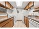 Efficient kitchen featuring ample wood cabinets, white appliances, and a skylight for natural light at 1792 S Pitkin Cir # B, Aurora, CO 80017