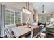 Bright dining room with a wooden table, modern chandelier, and large window at 6825 S Webster St # A, Littleton, CO 80128