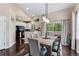 Dining room with wood floors, table, and chairs adjacent to the kitchen with white cabinets at 6825 S Webster St # A, Littleton, CO 80128