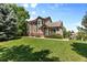 Attractive exterior view highlighting green front lawn and mature trees at 6825 S Webster St # A, Littleton, CO 80128