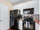 Kitchen featuring black appliances, tiled backsplash, and white cabinets at 6825 S Webster St # A, Littleton, CO 80128