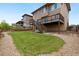 Lush backyard with wooden fence, deck and stairs and gravel beds, offering a serene outdoor retreat at 9486 Juniper Way, Arvada, CO 80007