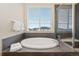 Bathroom with a large soaking tub and a separate glass-enclosed shower, and tiled walls at 9486 Juniper Way, Arvada, CO 80007