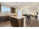 Spacious kitchen featuring a center island, granite countertops, and dark wood cabinetry, open to living space at 9486 Juniper Way, Arvada, CO 80007