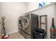Well-equipped laundry room with modern washer and dryer, plus storage shelving and ample space at 9486 Juniper Way, Arvada, CO 80007