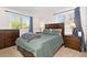 A bedroom with a wooden bed frame, matching dressers and side tables at 4374 E Peakview Cir, Centennial, CO 80121