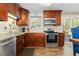 Well-equipped kitchen featuring dark wood cabinets, granite countertops, stainless steel appliances, and a stylish tile backsplash at 4374 E Peakview Cir, Centennial, CO 80121