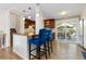 Kitchen with breakfast bar featuring seating, dark cabinets, hardwood floors, and a sliding glass door to the backyard at 4374 E Peakview Cir, Centennial, CO 80121