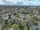 An aerial shot showcases a neighborhood with a mix of homes, lush trees, and nearby city skyline at 6544 E Alaska Dr, Denver, CO 80224