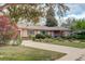 Charming brick home with mature landscaping, a lush lawn, and a welcoming driveway, perfect for curb appeal at 6544 E Alaska Dr, Denver, CO 80224