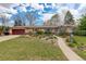 Charming brick ranch-style home with an attached garage, mature landscaping, and inviting walkway at 6544 E Alaska Dr, Denver, CO 80224