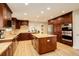 Gourmet kitchen featuring custom cabinetry, granite countertops, stainless steel appliances, and a central island at 6544 E Alaska Dr, Denver, CO 80224