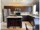 Well-equipped kitchen features stainless steel appliances, island with stool seating, and tile backsplash at 1354 Avgare Way, Erie, CO 80516