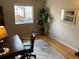 A simple home office space with neutral walls, a comfortable desk, and ample natural light from the window at 1354 Avgare Way, Erie, CO 80516