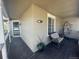 Cozy covered porch with hanging chair and neutral paint and dark wood flooring at 1354 Avgare Way, Erie, CO 80516