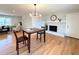 Open dining area features wood floors, a modern light fixture, and a charming brick fireplace at 2090 S Clinton St, Denver, CO 80231