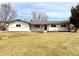 Ranch style home features light colored brick and siding, and a well maintained front yard at 2090 S Clinton St, Denver, CO 80231