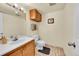 Neutral bathroom features tiled floor, oak vanity with sink, mounted mirror, updated lighting, toilet, and wall storage at 2351 Federal Blvd # 401, Denver, CO 80211
