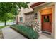 Inviting entrance with a stone-accented wall and a cozy red door adorned with a wreath at 10760 Eliot Cir # 204, Denver, CO 80234