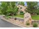 Charming home exterior with lush greenery and a stone sign that reads 