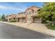 View of townhomes, showcasing garages, stone accents, and well-maintained landscaping at 10760 Eliot Cir # 204, Denver, CO 80234