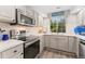 Bright kitchen with stainless steel appliances, herringbone tile backsplash, and quartz countertops at 10760 Eliot Cir # 204, Denver, CO 80234
