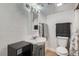 Simple bathroom with vanity, toilet, grey towels, and shower with curtain at 4849 S Pitkin Way, Aurora, CO 80015