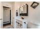 Modern bathroom showcasing a white vanity with dark hardware, toilet, and doorway to another room at 4849 S Pitkin Way, Aurora, CO 80015