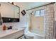 Clean bathroom featuring a vanity, toilet, shower/tub combo, and decorative mirror at 4849 S Pitkin Way, Aurora, CO 80015