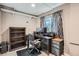 Functional office space with dark wooden desk, rolling chair, bookcase, and natural light from the window at 4849 S Pitkin Way, Aurora, CO 80015