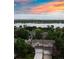 Aerial view of houses near the lake, with a beautiful sunset sky, and green trees at 849 Canary Ln, Brighton, CO 80601