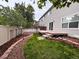 Lush backyard featuring a patio area surrounded by mulched landscaping and a well-maintained lawn at 849 Canary Ln, Brighton, CO 80601