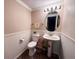 Charming powder room with pedestal sink and wainscoting at 849 Canary Ln, Brighton, CO 80601