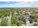 Aerial shot displays a neighborhood with tree-lined streets, a mix of houses, and distant mountain views at 2908 N Florence St, Denver, CO 80238