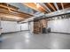 Unfinished basement with white-painted walls, grey concrete floor, and laundry area at 2908 N Florence St, Denver, CO 80238