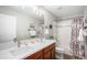 Bathroom featuring double sinks, quartz countertop, and shower-tub combination at 2908 N Florence St, Denver, CO 80238
